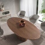 Oval dining table in walnut veneered wood.