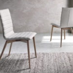 Chair upholstered in fabric with Walnut colored wooden legs