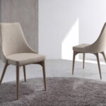 Chair upholstered in fabric with Walnut colored wooden legs