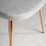 Chair upholstered in fabric with rose gold steel legs