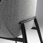 Chair upholstered in fabric with piping and black steel frame