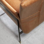 Armchair upholstered in leather and black steel legs