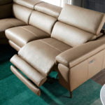 Corner sofa upholstered in leather with relax mechanism