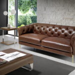 2 seater sofa upholstered in leather with golden polished steel legs