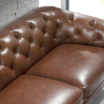 2 seater sofa upholstered in leather with golden polished steel legs