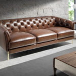 3 seater sofa upholstered in leather with golden polished steel legs