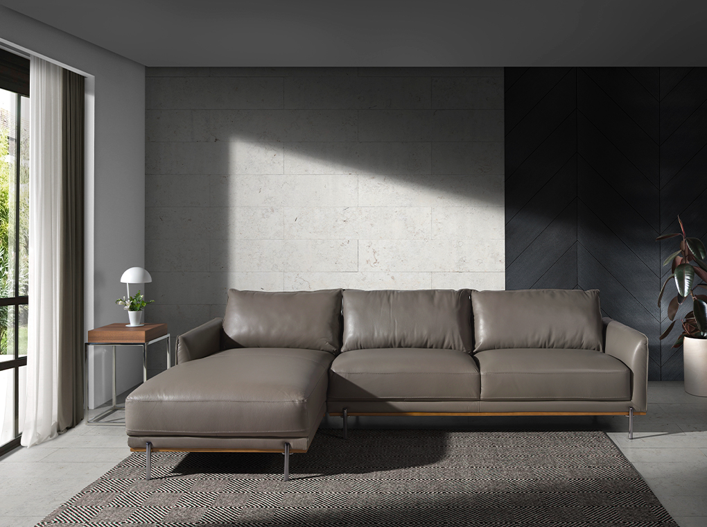 Chaise longue sofa upholstered in leather and legs in darkened steel.
