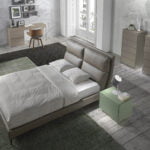 Bed upholstered in leatherette with cushions