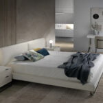 Bed upholstered in leatherette with polished steel legs