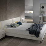 Letto rivestito in similpelle con gambe in acciaio lucido