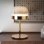 Table lamp in gilded steel with translucent glass shade