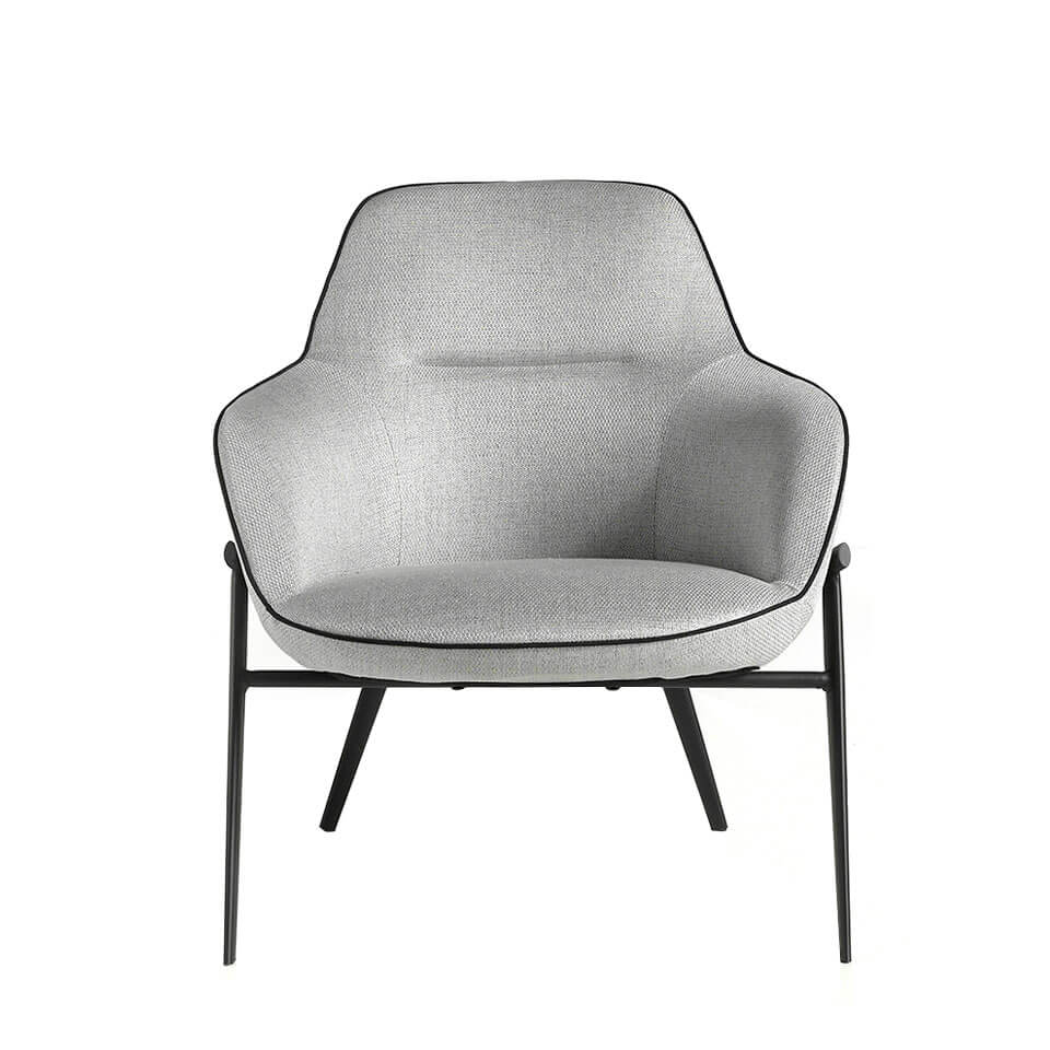 Confident armchair upholstered in fabric with piping