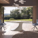 Oval dining table in porcelain marble and sand-coloured epoxy fiberglass