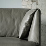 2-seater sofa upholstered in leather with polished steel legs