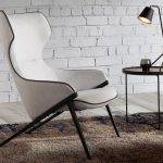 Armchair upholstered in fabric with black steel trim and legs
